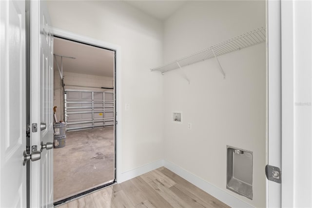 clothes washing area with hardwood / wood-style flooring and hookup for a washing machine