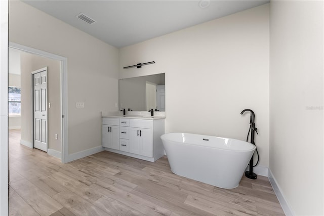 bathroom featuring a bathing tub, vanity, and wood-type flooring