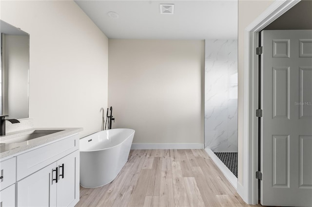 bathroom with shower with separate bathtub, vanity, and hardwood / wood-style flooring