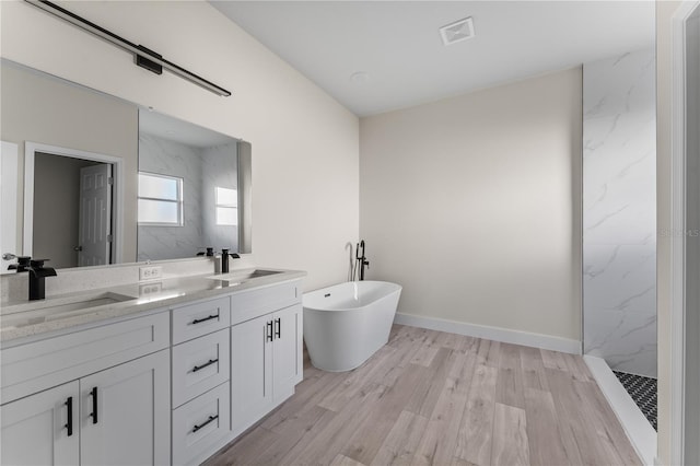 bathroom featuring hardwood / wood-style floors, vanity, and separate shower and tub