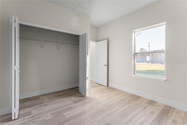 unfurnished bedroom featuring a closet and light hardwood / wood-style flooring