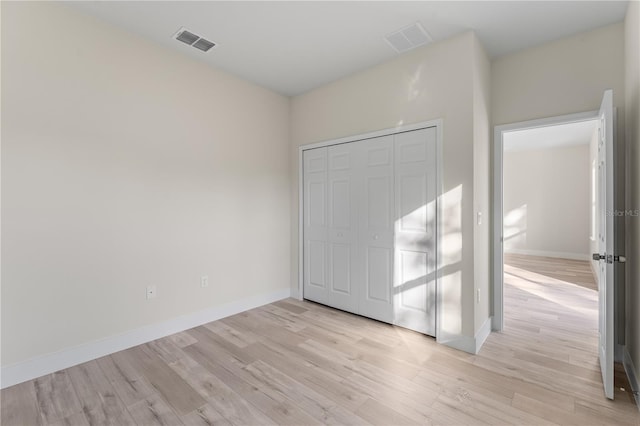 unfurnished bedroom featuring a closet and light wood-type flooring