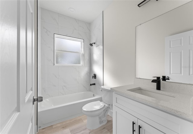 full bathroom with hardwood / wood-style floors, vanity, toilet, and tiled shower / bath