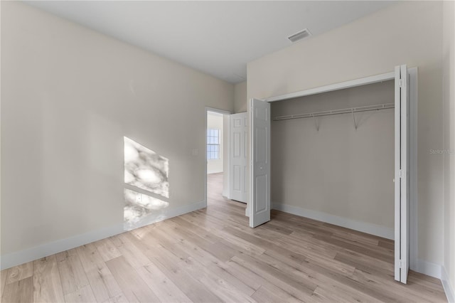 unfurnished bedroom with light hardwood / wood-style floors and a closet