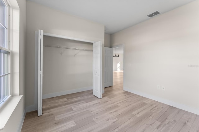 unfurnished bedroom with a closet and light wood-type flooring