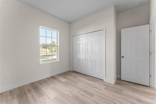 unfurnished bedroom featuring light hardwood / wood-style floors and a closet