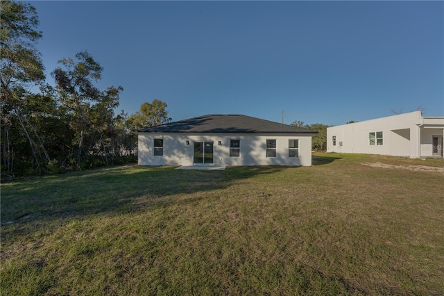 rear view of property featuring a lawn