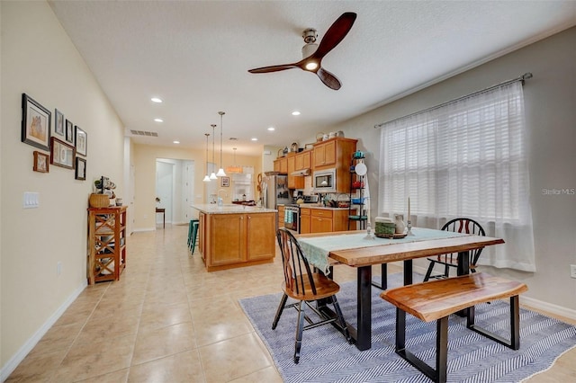 tiled dining space featuring a textured ceiling, ceiling fan, and sink