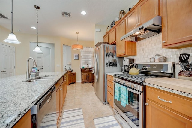 kitchen featuring pendant lighting, backsplash, sink, light tile patterned floors, and appliances with stainless steel finishes