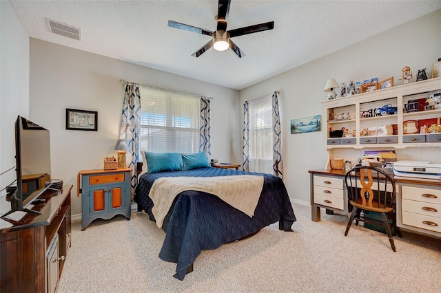 carpeted bedroom with ceiling fan and a textured ceiling