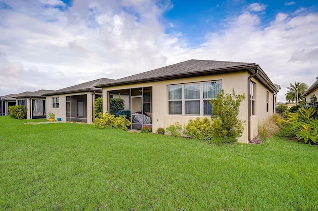 back of property with a sunroom and a yard