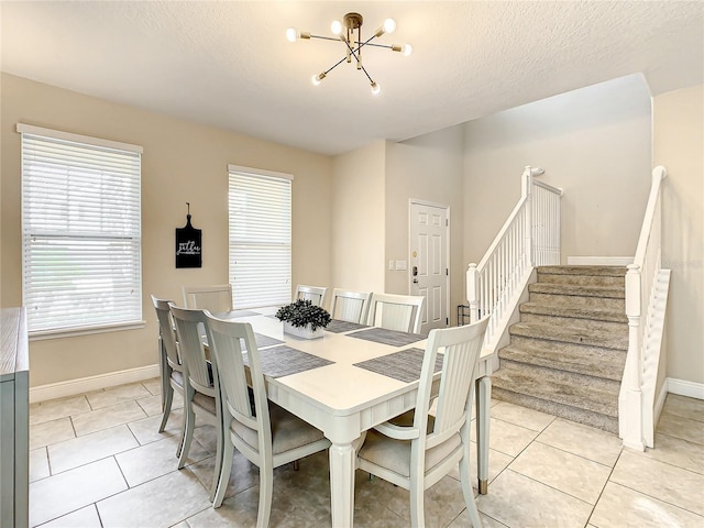 5303 Wildwood Way, Davenport, FL 33837 - dining space with a chandelier, stairs, light tile patterned flooring, and a textured ceiling