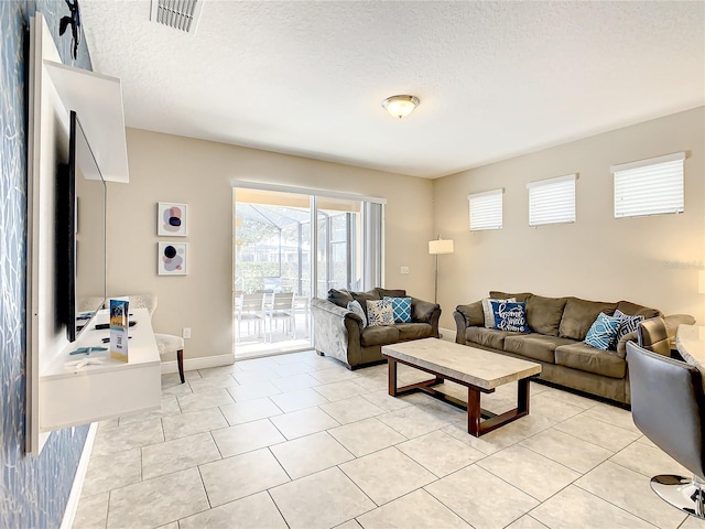 tiled living room featuring a textured ceiling