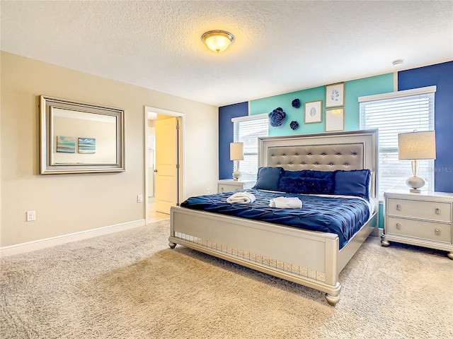 bedroom featuring light colored carpet and a textured ceiling