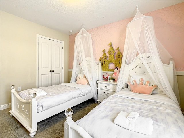 bedroom featuring dark carpet, a textured ceiling, and a closet