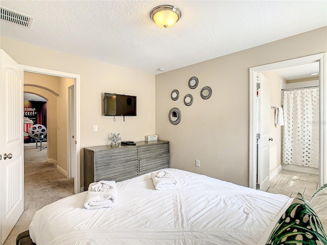 bedroom featuring a textured ceiling and light carpet