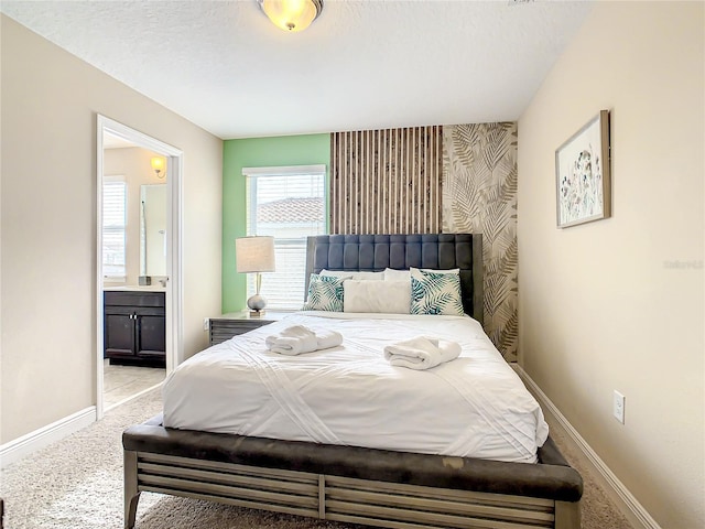 carpeted bedroom featuring a textured ceiling and connected bathroom