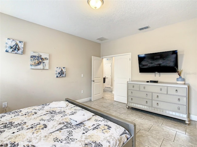 bedroom with light tile patterned floors and a textured ceiling