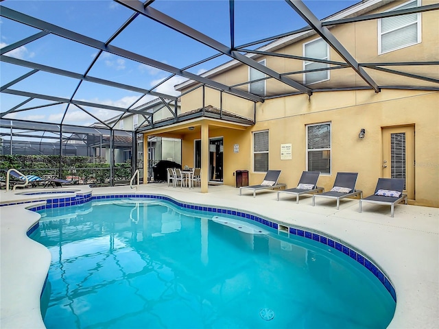 view of pool featuring glass enclosure and a patio area