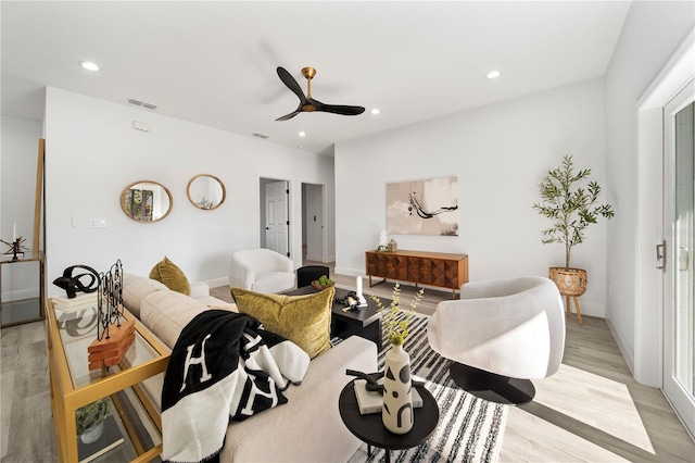 living room with ceiling fan and light hardwood / wood-style flooring