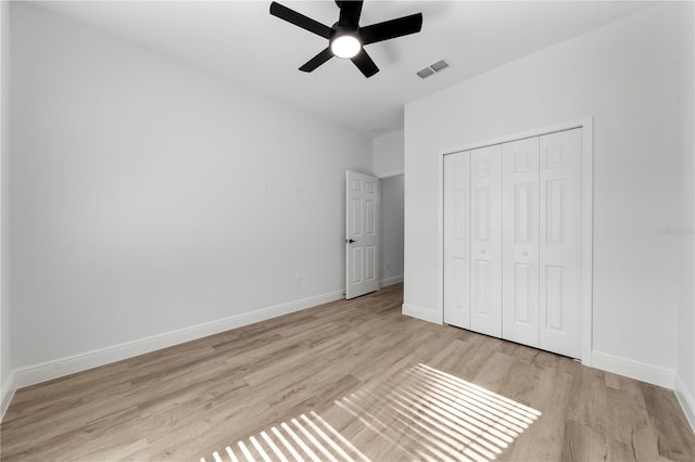 unfurnished bedroom with ceiling fan, light hardwood / wood-style floors, and a closet