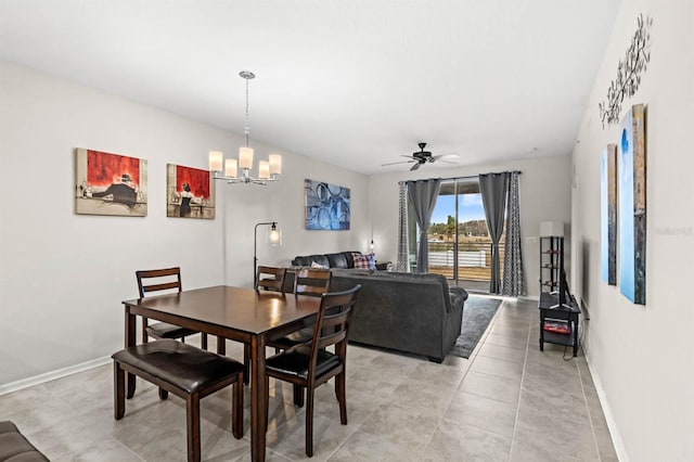 tiled dining room with ceiling fan with notable chandelier