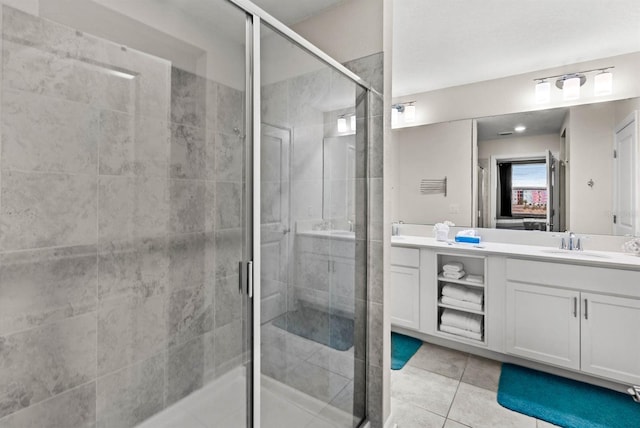 bathroom featuring tile patterned floors, vanity, and a shower with door