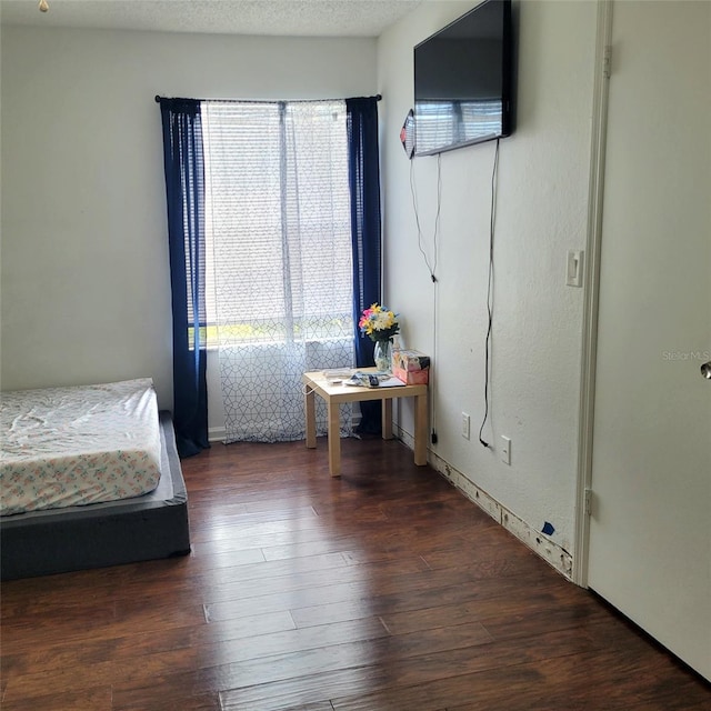 unfurnished bedroom featuring dark hardwood / wood-style flooring and a textured ceiling