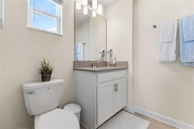 bathroom featuring tile patterned flooring, vanity, and toilet