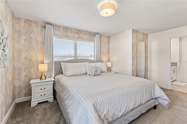 bedroom featuring a textured ceiling, connected bathroom, and carpet floors