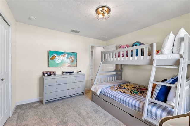 carpeted bedroom featuring a textured ceiling and a closet