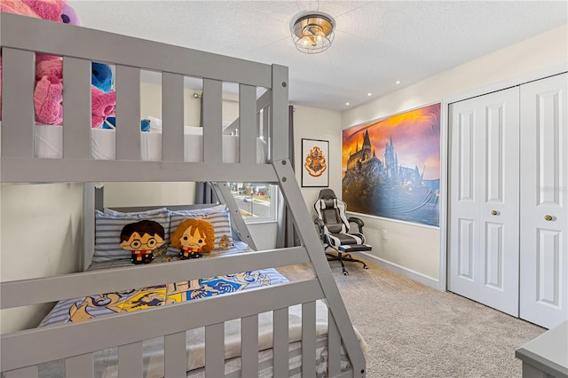 carpeted bedroom with a closet and a textured ceiling