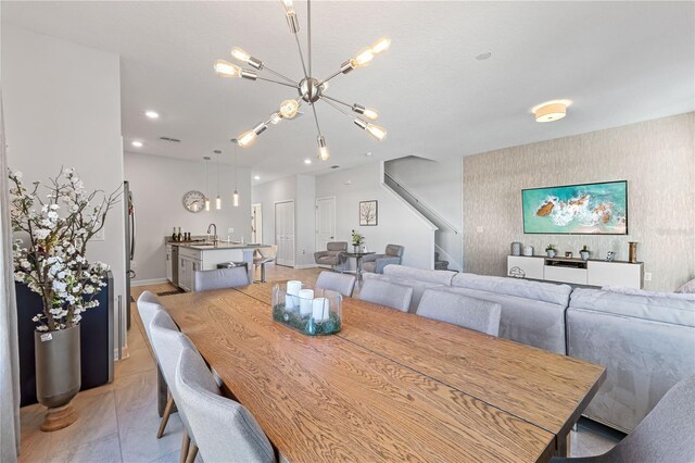 tiled dining room featuring sink and a notable chandelier