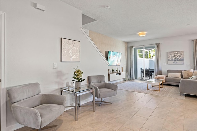 living area featuring light tile patterned floors and a textured ceiling