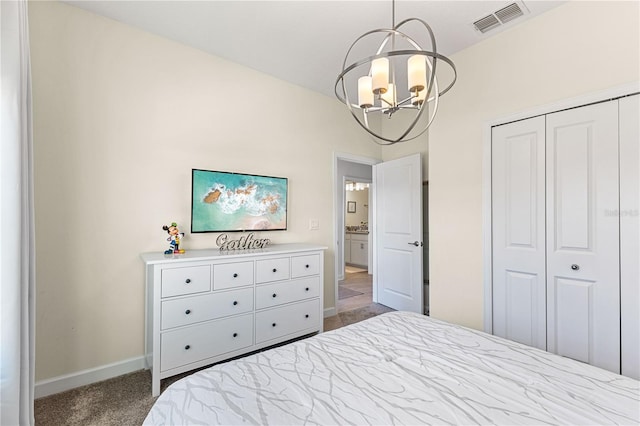 carpeted bedroom featuring an inviting chandelier and a closet