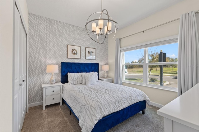 bedroom featuring an inviting chandelier, dark carpet, and a closet