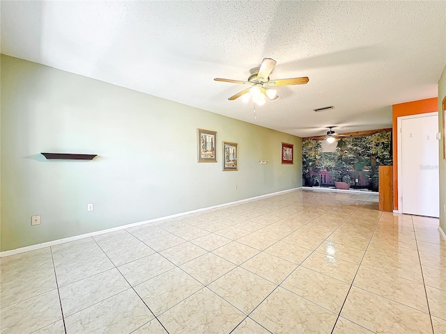 tiled spare room with a textured ceiling and ceiling fan