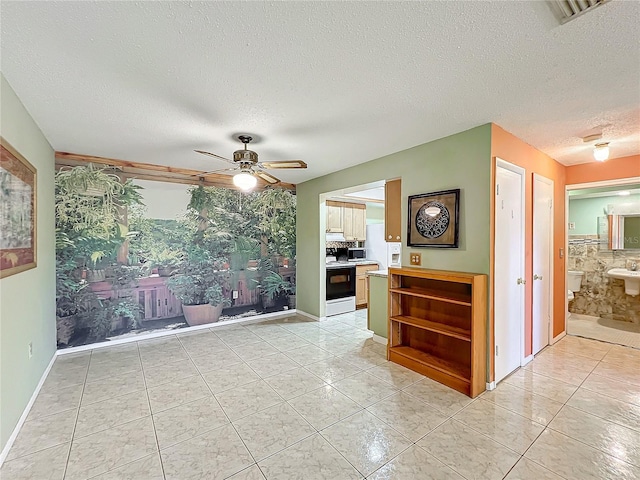 interior space with light tile patterned flooring, a textured ceiling, ceiling fan, and electric stove