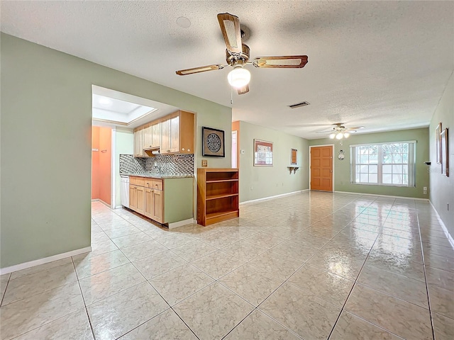 kitchen featuring light tile patterned floors, a textured ceiling, and tasteful backsplash