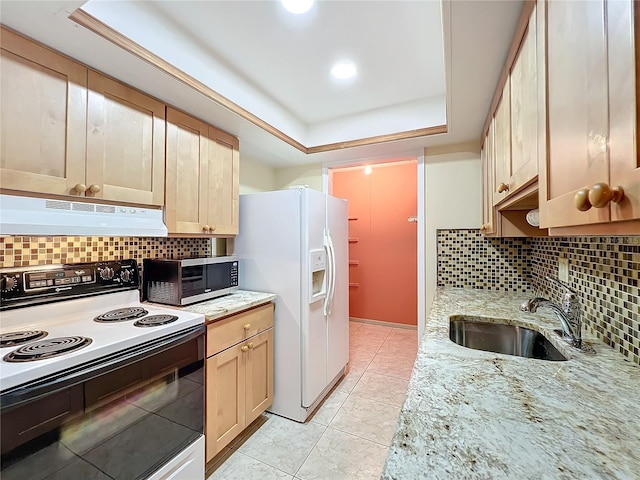 kitchen with light brown cabinets, white appliances, a raised ceiling, sink, and light tile patterned floors