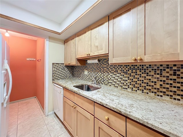 kitchen with light stone countertops, backsplash, white appliances, sink, and light tile patterned flooring