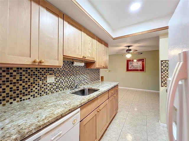 kitchen with white appliances, sink, light stone countertops, light brown cabinetry, and tasteful backsplash