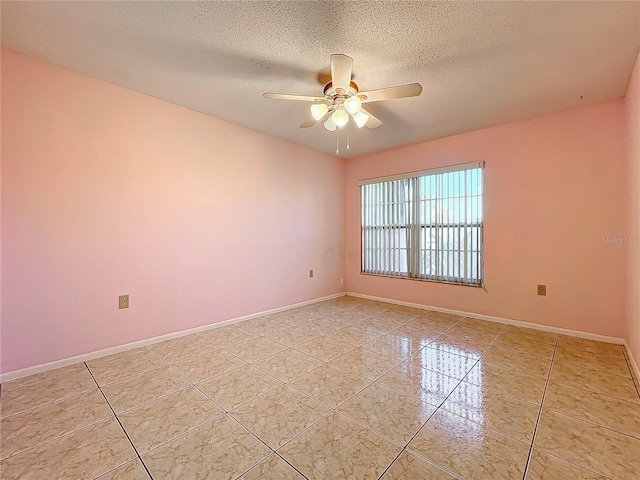 tiled empty room featuring ceiling fan and a textured ceiling