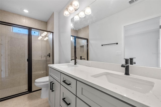 bathroom featuring tile patterned floors, vanity, toilet, and a shower with door