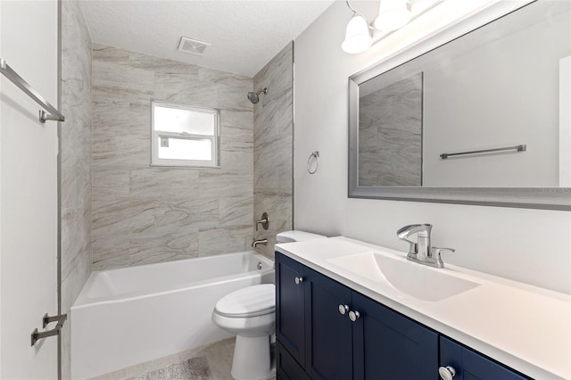 full bathroom with tile patterned flooring, a textured ceiling, toilet, vanity, and tiled shower / bath