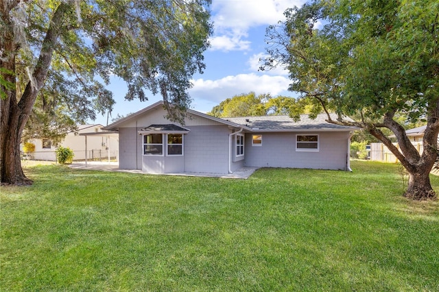 rear view of property with a lawn