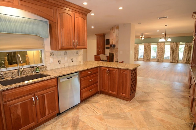 kitchen with sink, stainless steel dishwasher, backsplash, kitchen peninsula, and ceiling fan with notable chandelier