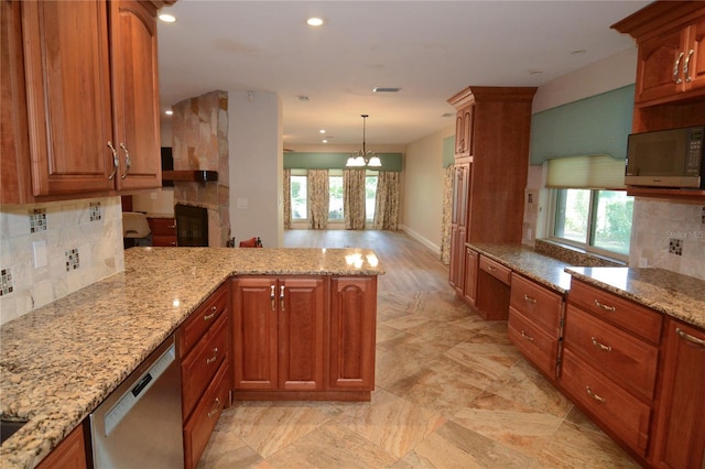 kitchen featuring backsplash, light stone counters, hanging light fixtures, and appliances with stainless steel finishes