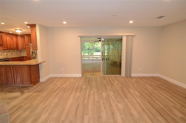 unfurnished living room featuring light hardwood / wood-style flooring and ceiling fan