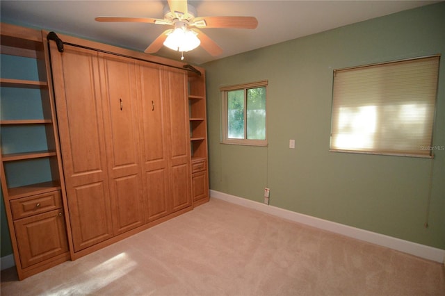 unfurnished bedroom featuring ceiling fan and light colored carpet